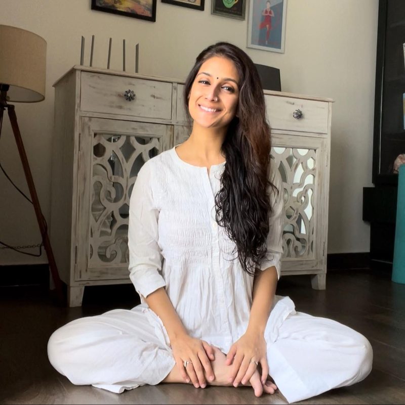 Shikha smiling, seated at home